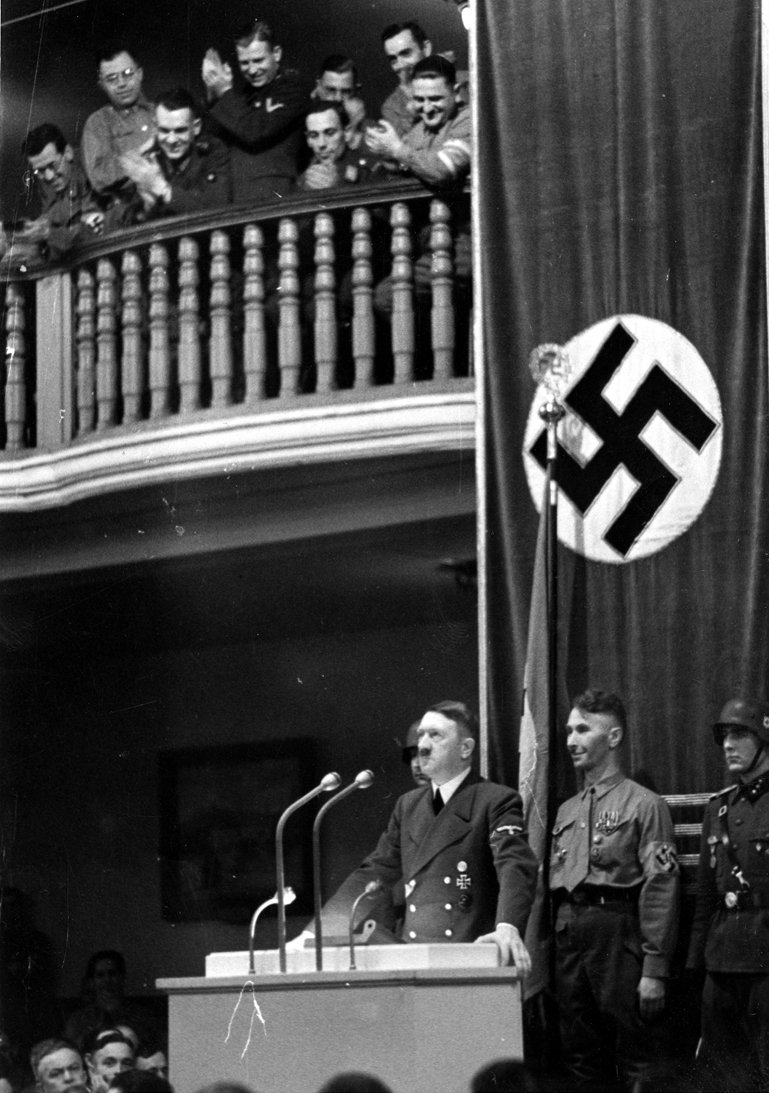 Adolf Hitler speaking to participants of the 1923 Beer Hall Putsch just before the failed bombing attempt by Georg Elser. The bomb was placed in the pillar behind Hitler.